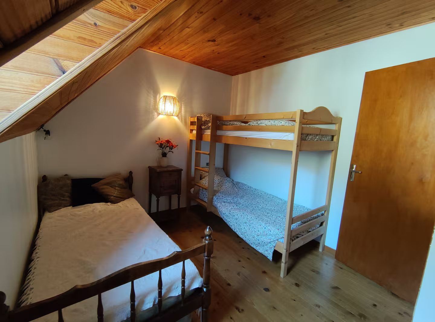 La chambre avec des lits superposés et un lit simple